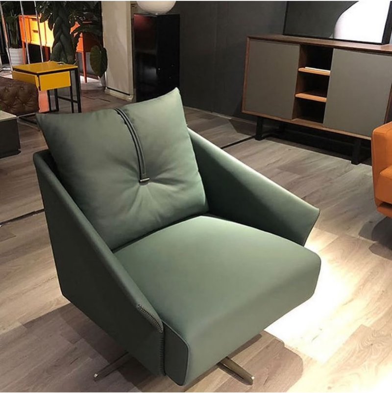 green swivel accent chair with decorative strap detail